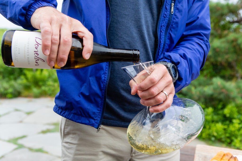 up close photo of chardonnay being poured into a decanter