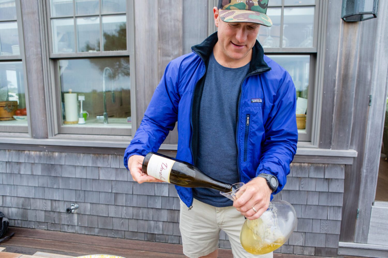 Cushing Donelan pouring a bottle of Chardonnay into a glass decanter